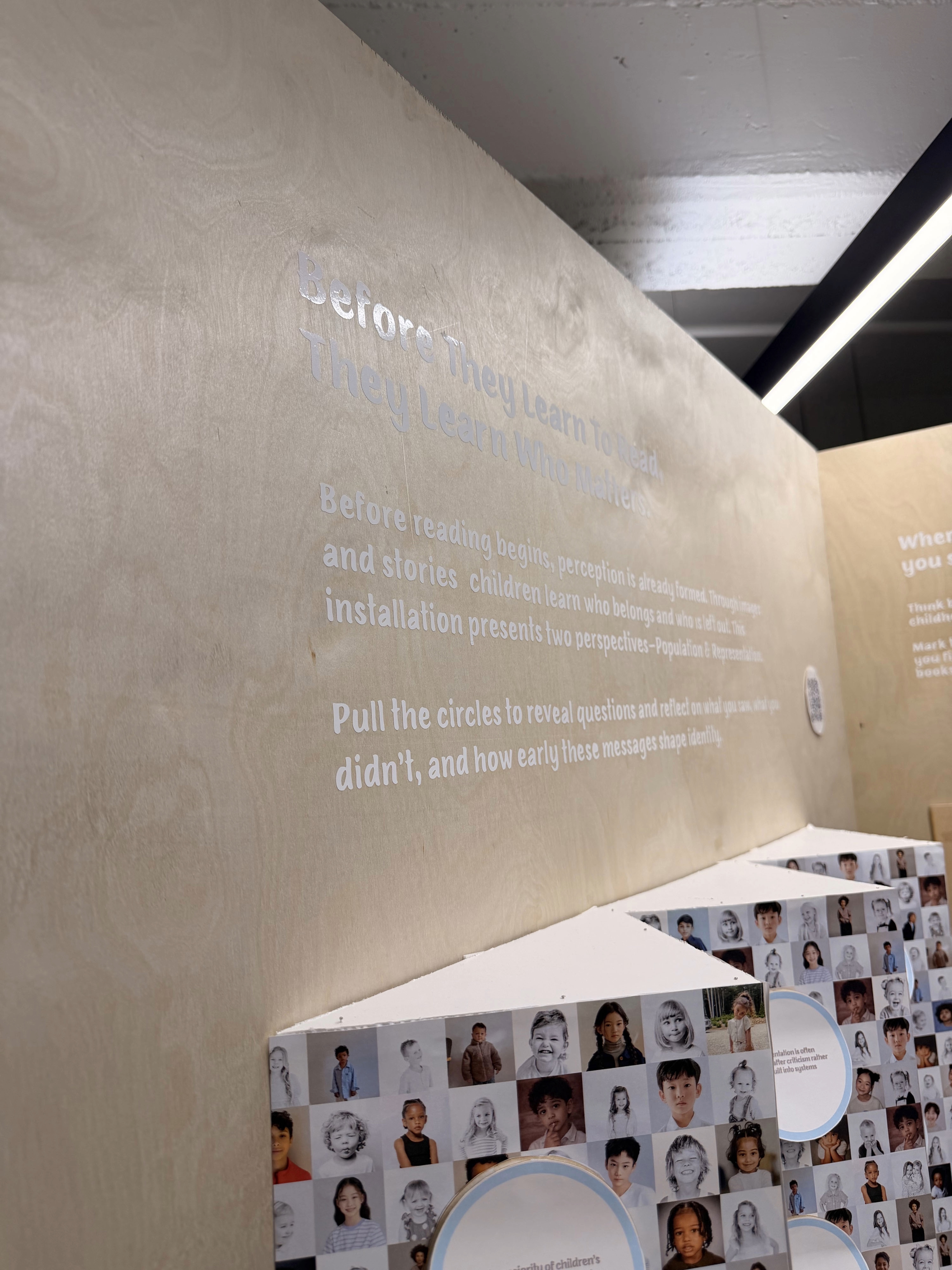 Close-up of the vinyl wall text Before They Learn To Read, They Learn Who Matters