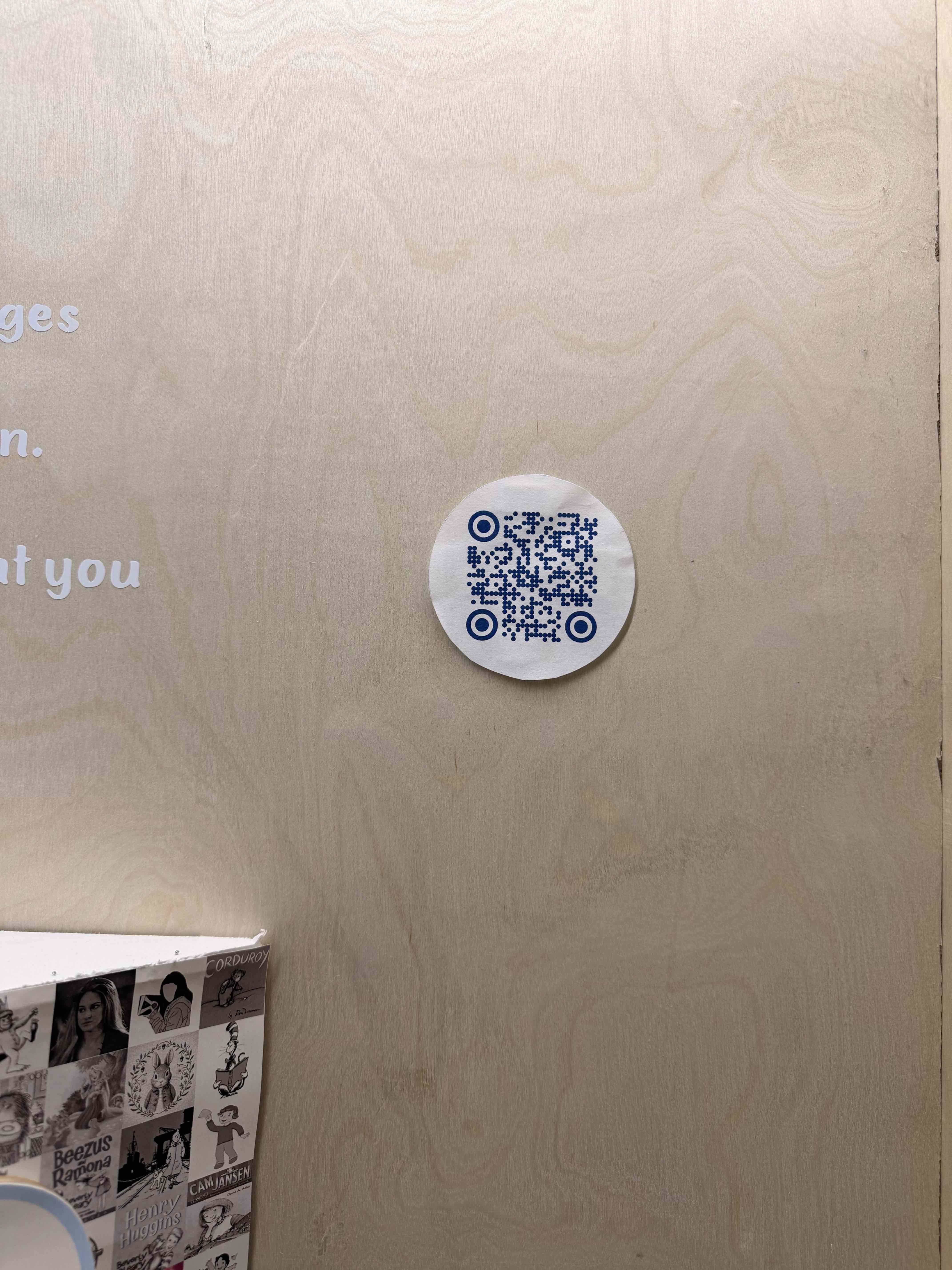 Circular QR code sticker on the plywood wall